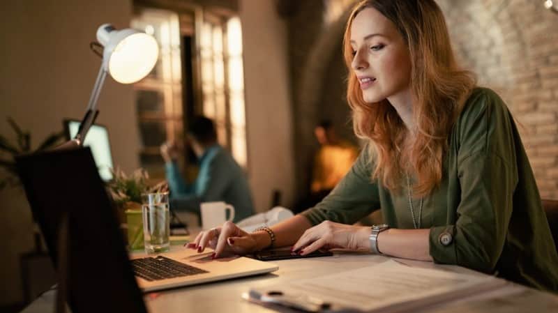 Modern ofiste laptop başında içerik yazan kadın; arama niyetine uygun SEO içerik rehberi kapağı